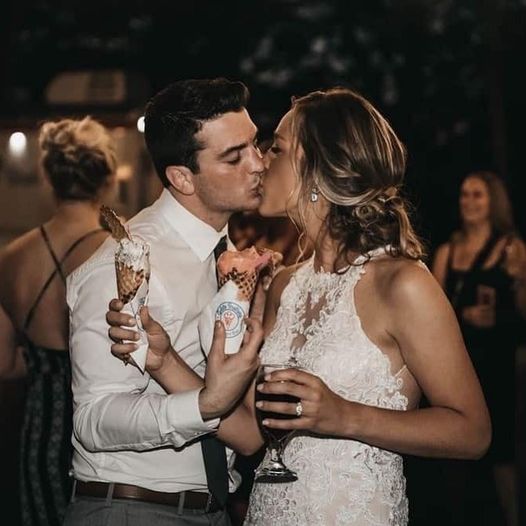 Newlyweds kissing while holding Gelato Brothers waffle cones